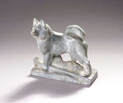 statue représentant un chien debout sur un rocher, posée sur un fond blanc