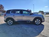 the silver suv is parked in a parking lot near a gas station