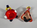 two figurines of a man and a woman holding a red ball