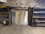 a metal dishwasher sitting in a dirty room