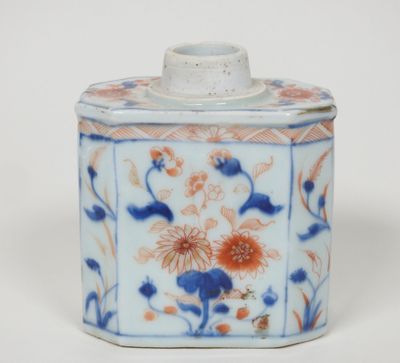 un petit récipient bleu et blanc orné de fleurs