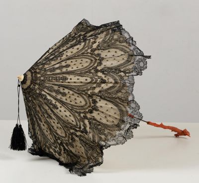 un parapluie en dentelle noire orné d'un pompon