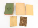 three old books sitting on top of each other on a white surface
