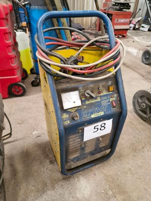 une soudeuse bleue et jaune posée dans un garage