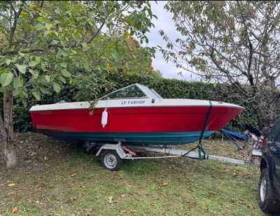 a picture of a red and white boat on a trailer