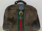 un sac en papier brun orné d'une rayure verte, rouge et verte