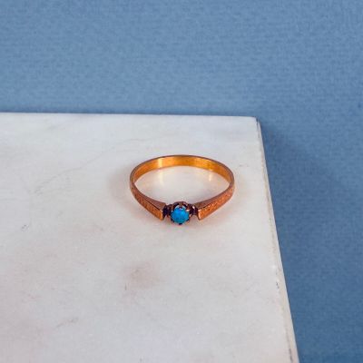 une bague sertie d'une pierre bleue, posée sur une table