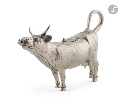 une image représentant une figurine de vache en argent sur fond blanc