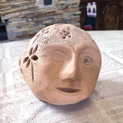 une sculpture en argile représentant un visage, posée sur une table