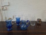 quatre vases en verre bleu posés les uns à côté des autres sur une table