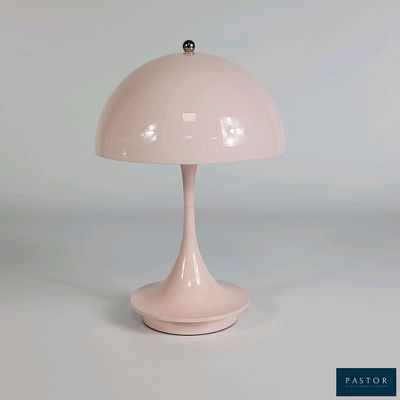 une lampe rose posée sur une table blanche