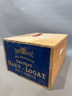 une vieille boîte en bois sur laquelle est collée une étiquette portant l'inscription « Château Haut Logat »