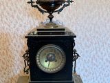 une horloge noire posée sur une table noire