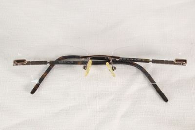 une image représentant une paire de lunettes posée sur un drap blanc