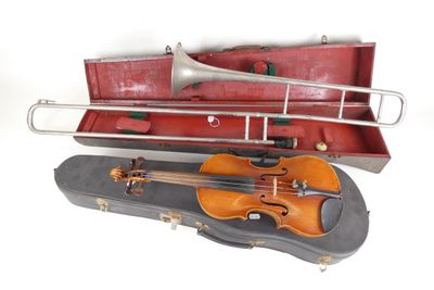 un violon et une trompette dans un étui posé sur une surface blanche