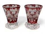 pair of red glass vases sitting on top of a white surface