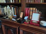 many books on a book shelf with a clock and other items