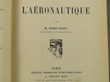 un livre ouvert posé sur une table, à côté d'une lampe