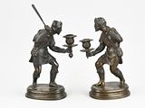 paire de figurines en bronze représentant un homme et une femme tenant un oiseau