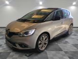 une voiture argentée est garée dans une pièce au sol en damier