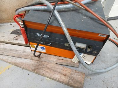 une machine orange et noire posée sur une palette en bois