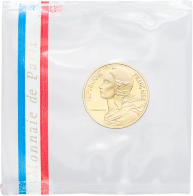 un gros plan d'une pièce de monnaie dans un sachet en plastique posé sur une surface blanche