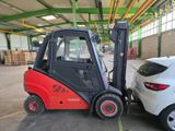 a forklift truck parked next to a car in a warehouse