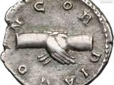 a close up of a coin with a hand on it