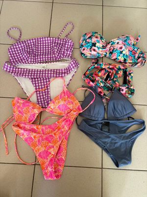a group of swimsuits laid out on a tiled floor