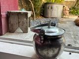 a tea pot sitting on a window sill next to a cat