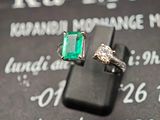 une bague ornée d'une pierre verte posée sur un panneau