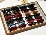 de nombreuses paires de lunettes de soleil dans une vitrine posée sur une table