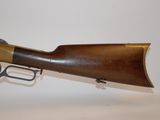an old rifle with a wooden barrel and brass handle on a white background