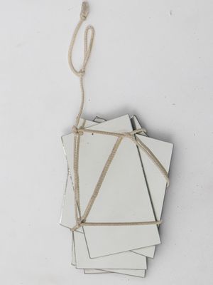 several pieces of white paper tied to a string on a white surface