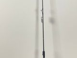 a close up of a fishing rod on the ground near a bag