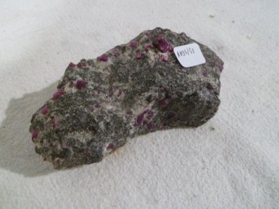 a rock with a tag on it sitting on a white surface