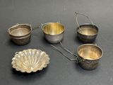 quatre couverts posés sur une surface noire, sur fond noir