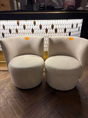 two white chairs sitting next to each other on a wooden floor