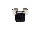 a close up of a silver cuff with a black stone on it
