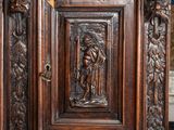 a wooden cabinet with carvings on it in a room