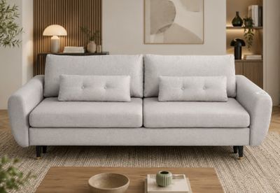 un canapé blanc placé dans un salon, à côté d'une table basse