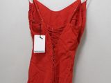 a red dress hanging on a hanger against a white wall