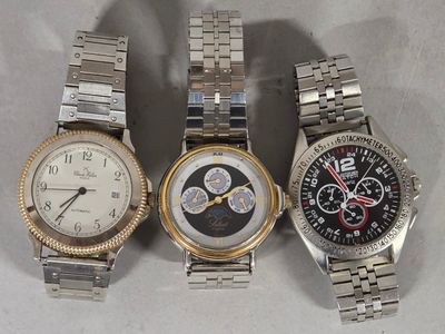 three watches are sitting side by side on a white surface