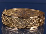 bracelet en or au motif raffiné sur une surface brillante