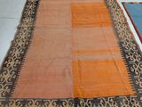 an orange and black rug on a white floor in a room