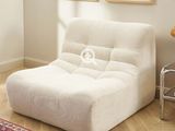 une chaise blanche qui se trouve dans une pièce où il y a des tableaux accrochés au mur