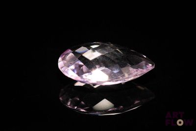 a close up of a pink diamond on a black surface