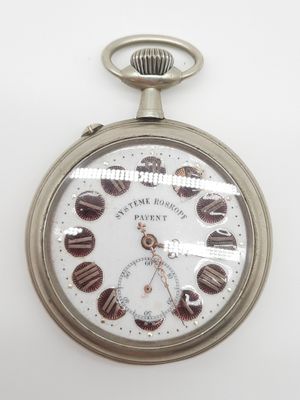 une montre de poche en argent posée sur une surface blanche, sur fond blanc