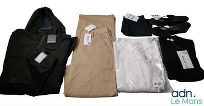 plusieurs paires de pantalons et de chemises pour homme disposées sur une surface blanche
