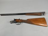 a rifle with a wooden handle and a wooden barrel on a white surface
